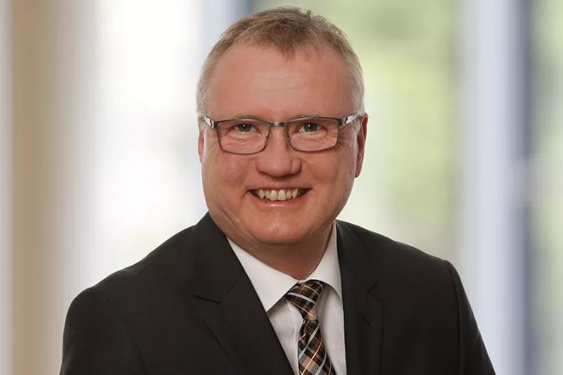 Portraitfoto des Abteilungsleiters, ein freundlicher Mann mit Anzug und Brille