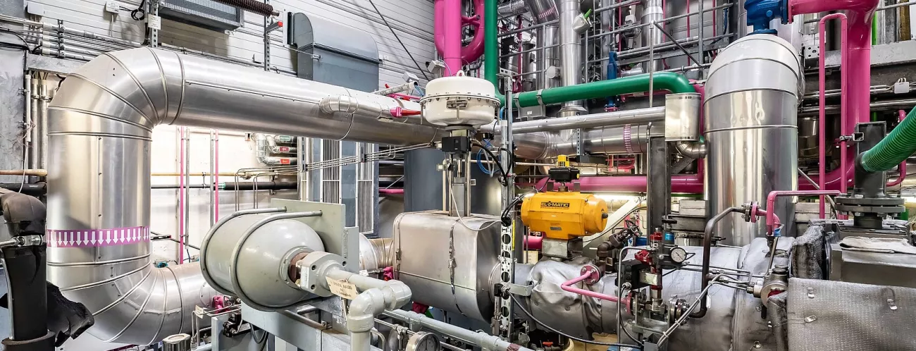 Geothermieanlage in einer Halle, bestehend aus vielen silbernen Rohren